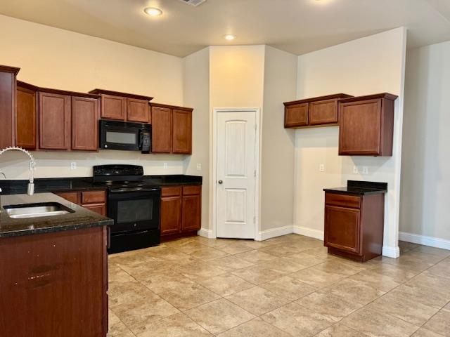 606 Memorial Ct, Midland, TX 79706 - kitchen with black appliances, a sink, baseboards, dark stone counters, and brown cabinets