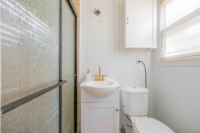 bathroom featuring vanity, toilet, and an enclosed shower