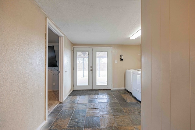 doorway to outside with washing machine and clothes dryer, french doors, and a textured ceiling