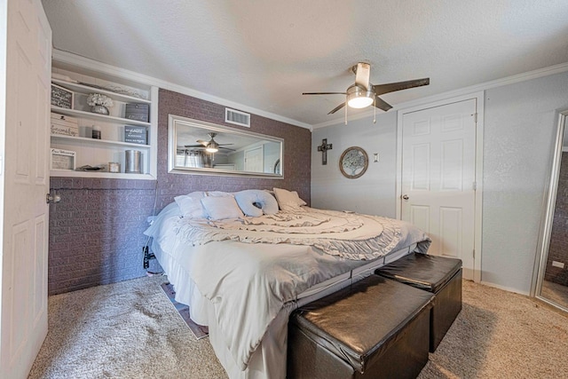 bedroom with ceiling fan, crown molding, carpet floors, and a textured ceiling