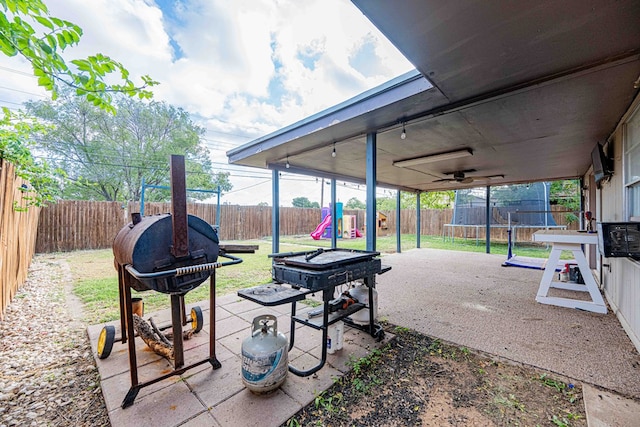 view of patio / terrace featuring a playground, a trampoline, and a grill