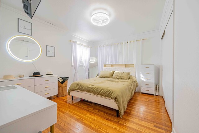 bedroom featuring light wood-type flooring and ornamental molding