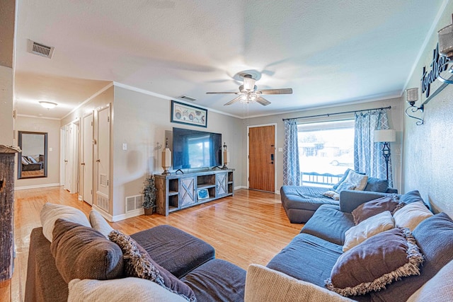 living room with ceiling fan, ornamental molding, a textured ceiling, and hardwood / wood-style flooring