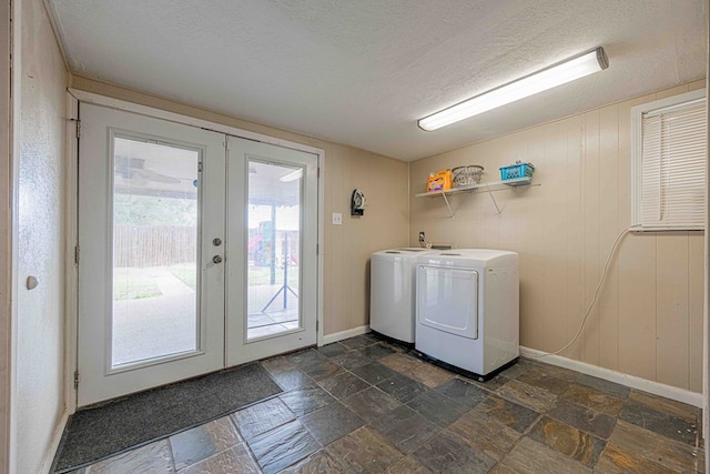 laundry room with separate washer and dryer, wood walls, french doors, and a textured ceiling