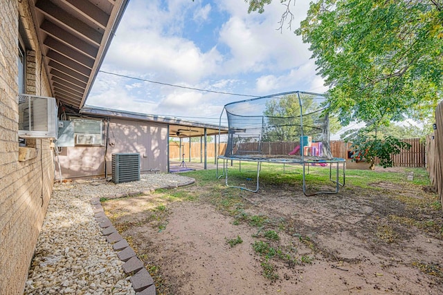 view of yard with a playground, a trampoline, and central air condition unit