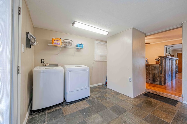 laundry area with washer and clothes dryer and a textured ceiling