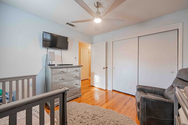 bedroom with ceiling fan, a closet, and light hardwood / wood-style floors