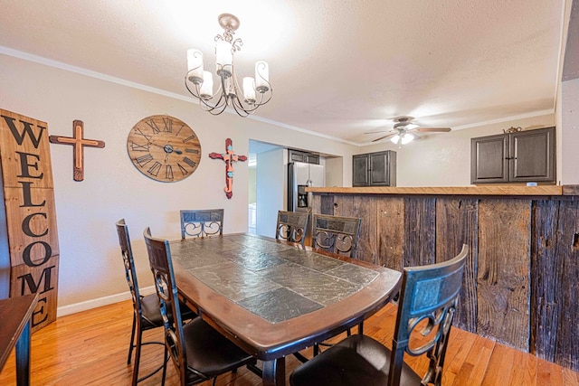 dining room with ceiling fan with notable chandelier, light hardwood / wood-style flooring, and crown molding