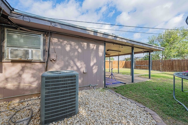 exterior space featuring a trampoline, central air condition unit, and a yard