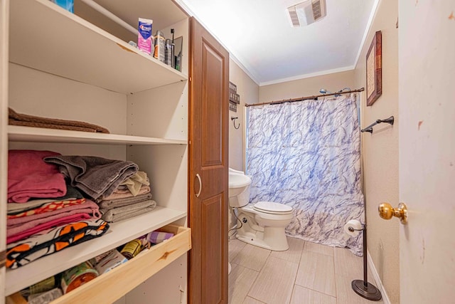 bathroom with crown molding and toilet