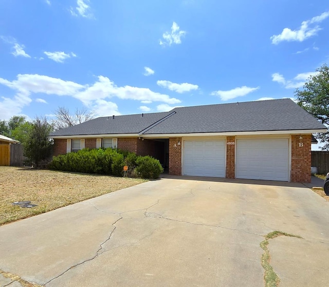 view of front of house with brick siding, concrete driveway, a garage, and fence