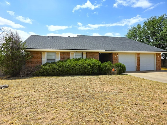 single story home with driveway, brick siding, and a garage