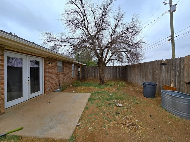 fenced backyard with french doors and a patio