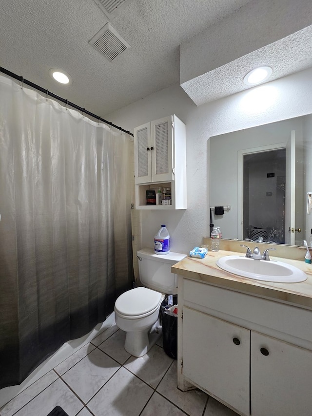 bathroom with a textured ceiling, toilet, vanity, tile patterned flooring, and curtained shower