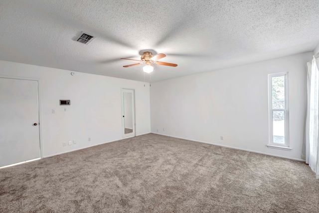 carpeted spare room with a textured ceiling and ceiling fan