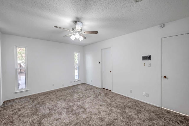 carpeted empty room with a healthy amount of sunlight and a textured ceiling