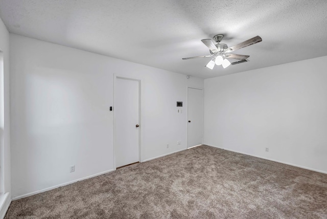 carpeted spare room with ceiling fan and a textured ceiling