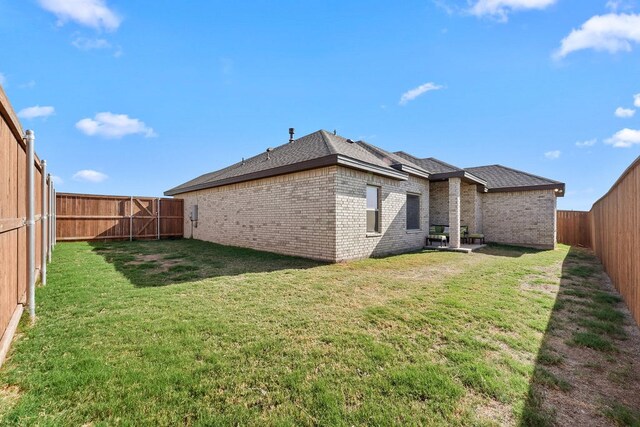 8514 Santa Isabella, Odessa, TX 79765 - rear view of property with a yard, brick siding, and a fenced backyard