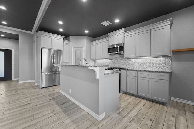 8514 Santa Isabella, Odessa, TX 79765 - kitchen featuring light wood-style floors, decorative backsplash, visible vents, and appliances with stainless steel finishes