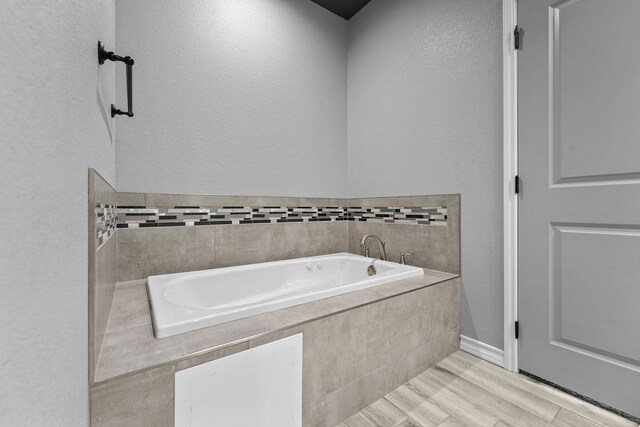 8514 Santa Isabella, Odessa, TX 79765 - full bathroom with a textured wall, a garden tub, baseboards, and wood finished floors