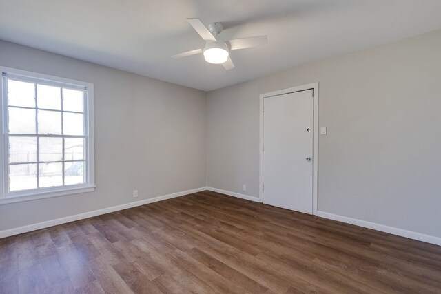 empty room with ceiling fan and dark hardwood / wood-style floors