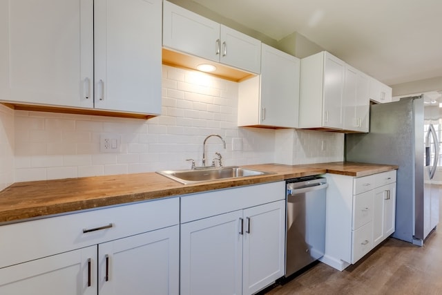 kitchen featuring butcher block countertops, sink, and white cabinets