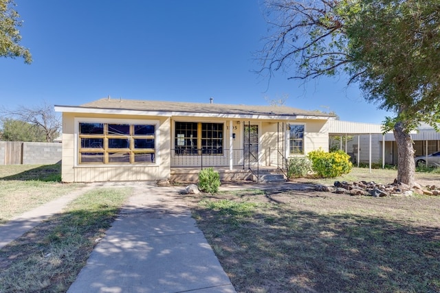 ranch-style home featuring covered porch and a carport