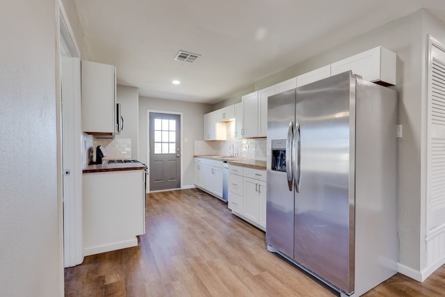 kitchen with white cabinets, light wood-type flooring, sink, and appliances with stainless steel finishes