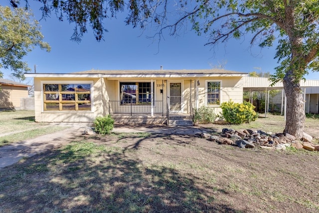 ranch-style house with a porch and a carport