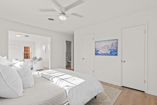 bedroom with ensuite bath, ceiling fan, and light hardwood / wood-style flooring