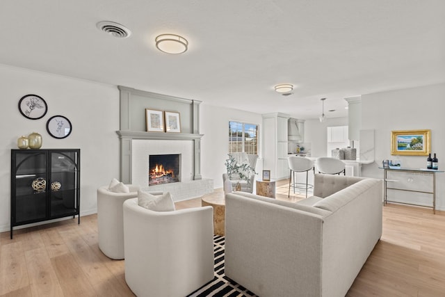 living room with a fireplace and light hardwood / wood-style flooring