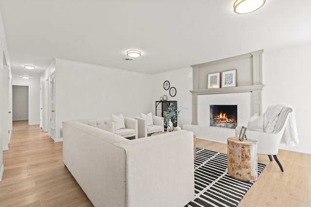 living room with light wood-type flooring and a fireplace