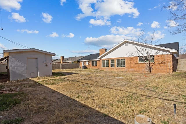 back of property with a storage shed