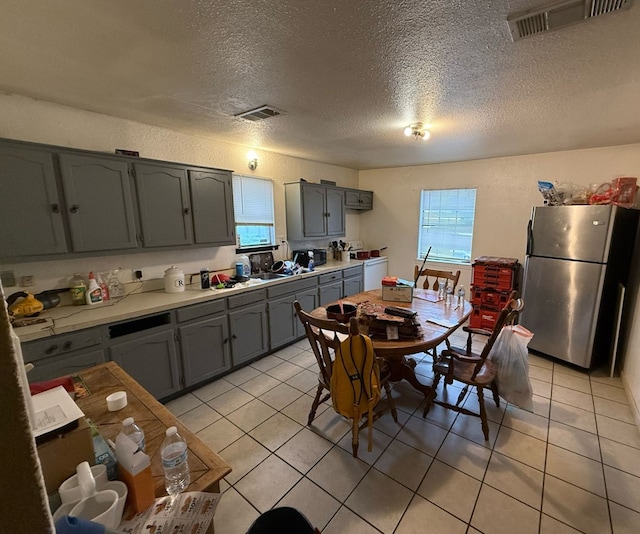 106 Walcott, Midland, TX 79701 - kitchen with a textured ceiling, visible vents, freestanding refrigerator, and light countertops
