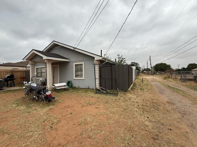 106 Walcott, Midland, TX 79701 - exterior space featuring fence, dirt driveway, and stucco siding