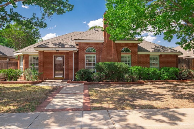 1608 Castleford Rd, Midland, TX 79705 - view of front facade with fence, a shingled roof, and brick siding
