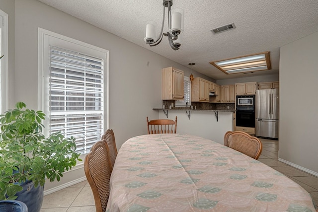 1608 Castleford Rd, Midland, TX 79705 - dining area featuring baseboards, visible vents, light tile patterned floors, and an inviting chandelier