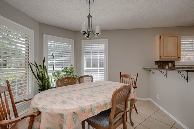 1608 Castleford Rd, Midland, TX 79705 - dining space with baseboards, a textured ceiling, an inviting chandelier, and light tile patterned floors