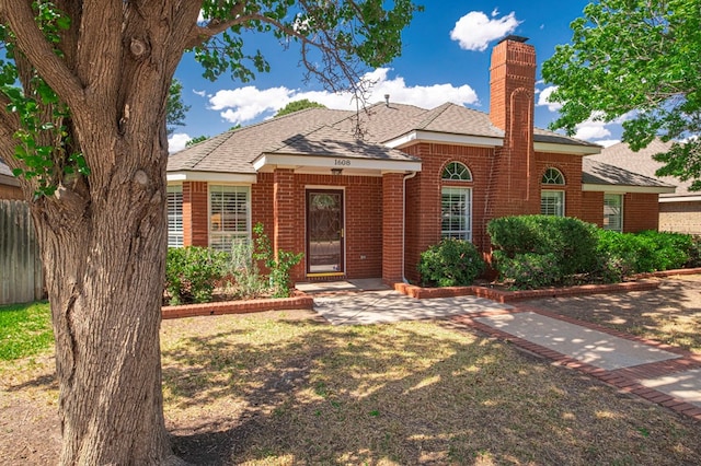 1608 Castleford Rd, Midland, TX 79705 - view of front of home with brick siding, roof with shingles, and a chimney