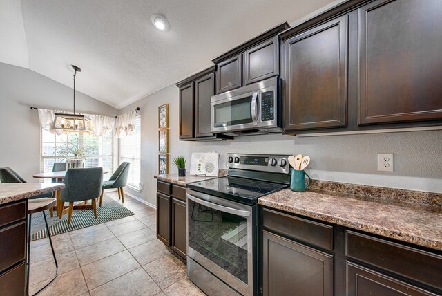 kitchen featuring an inviting chandelier, appliances with stainless steel finishes, vaulted ceiling, and dark brown cabinets