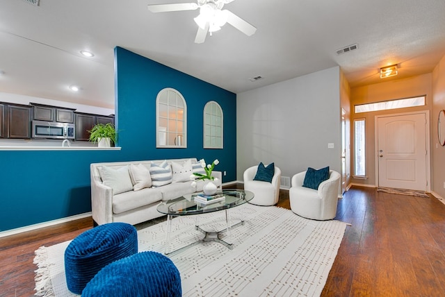 living room featuring baseboards, dark wood-style floors, and visible vents