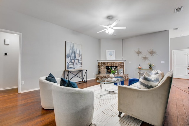 living area with ceiling fan, visible vents, and wood finished floors