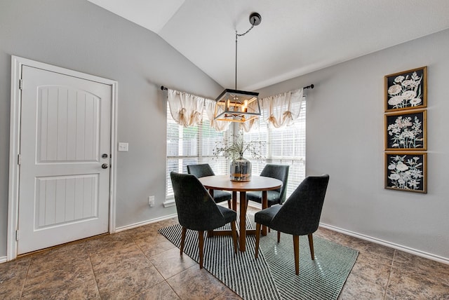 dining space featuring tile patterned flooring, a chandelier, and vaulted ceiling