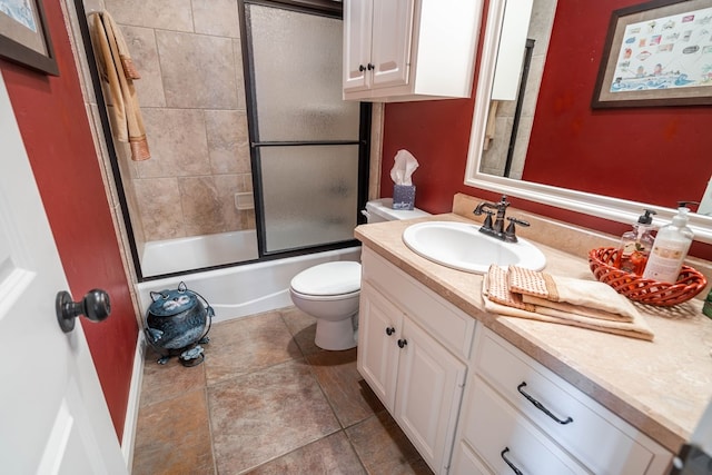 bathroom with tile patterned floors, toilet, vanity, and bath / shower combo with glass door