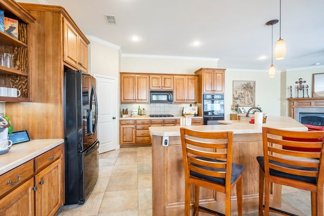 kitchen with brown cabinetry, decorative backsplash, black appliances, and light countertops