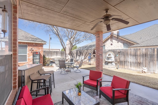 view of patio with an outdoor living space, a fenced backyard, outdoor dining space, and ceiling fan