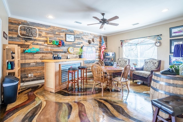 dining room featuring crown molding, a dry bar, visible vents, and ceiling fan