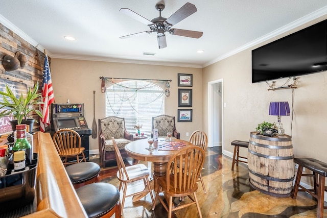 dining room with crown molding, baseboards, visible vents, and ceiling fan