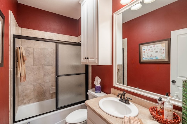 full bathroom featuring combined bath / shower with glass door, toilet, and vanity