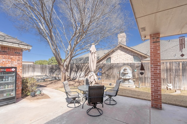 view of patio / terrace featuring beverage cooler and a fenced backyard